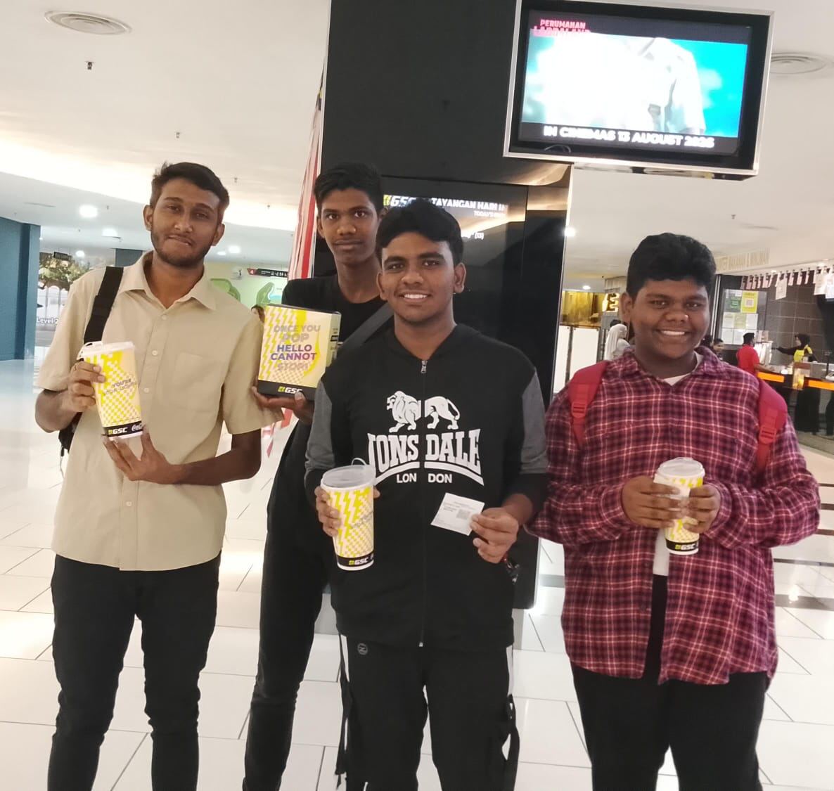 Young men holding popcorn and drinks at the cinema