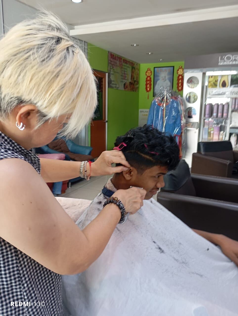 A volunteer giving a boy a haircut at the salon