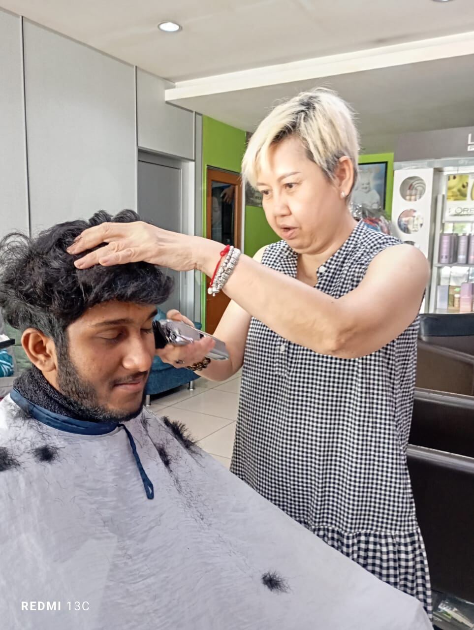 A volunteer giving a young man a haircut