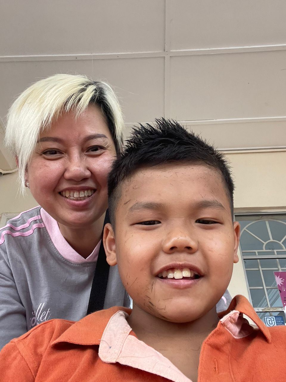 A caregiver and a young boy at Bright Future Home, smiling together