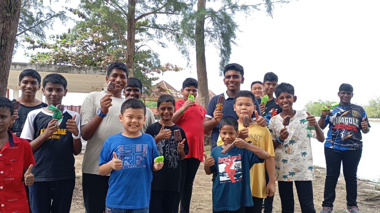 Boys enjoying ice cream together by the lake