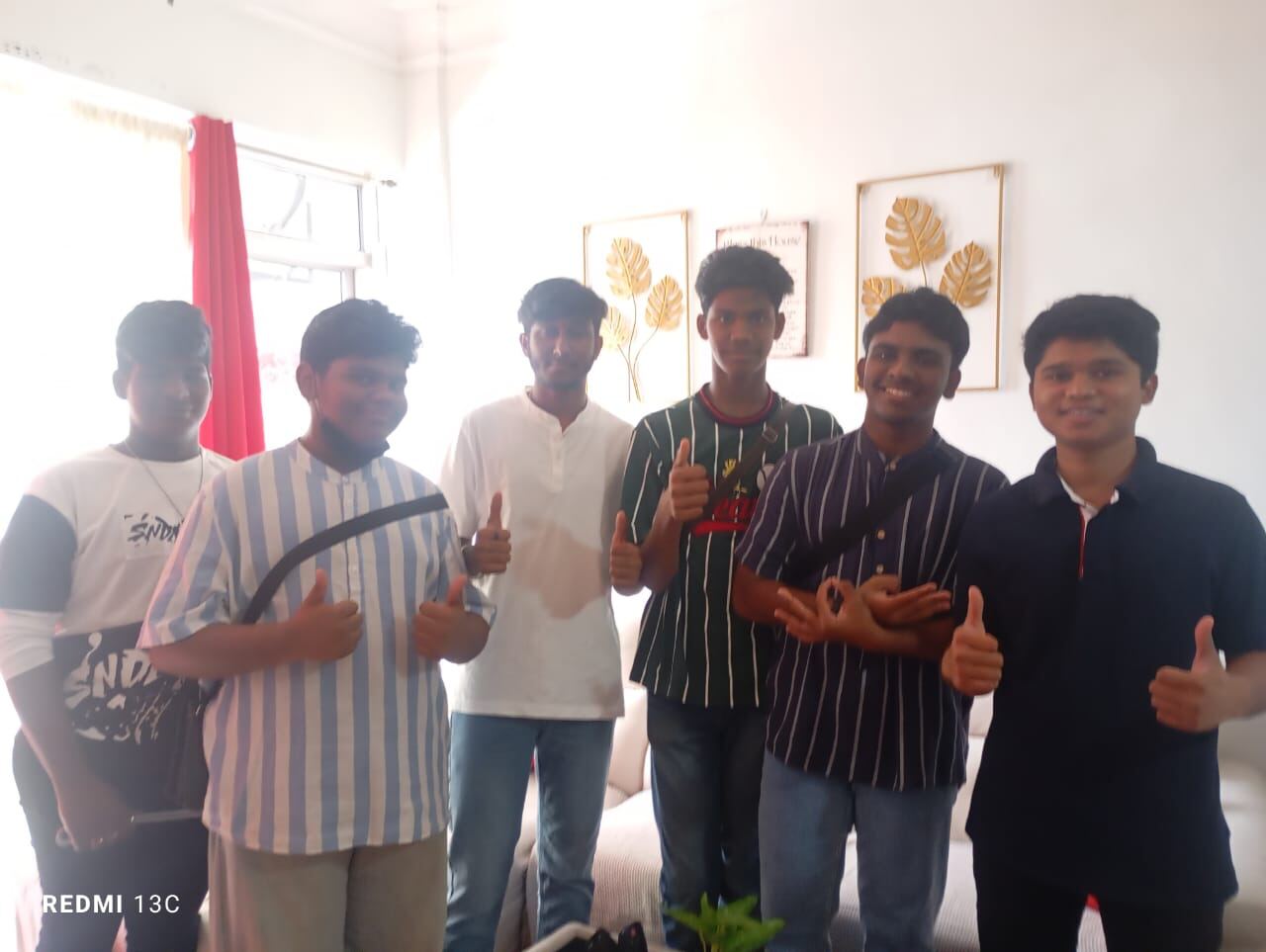 A group of young men posing together in the living room