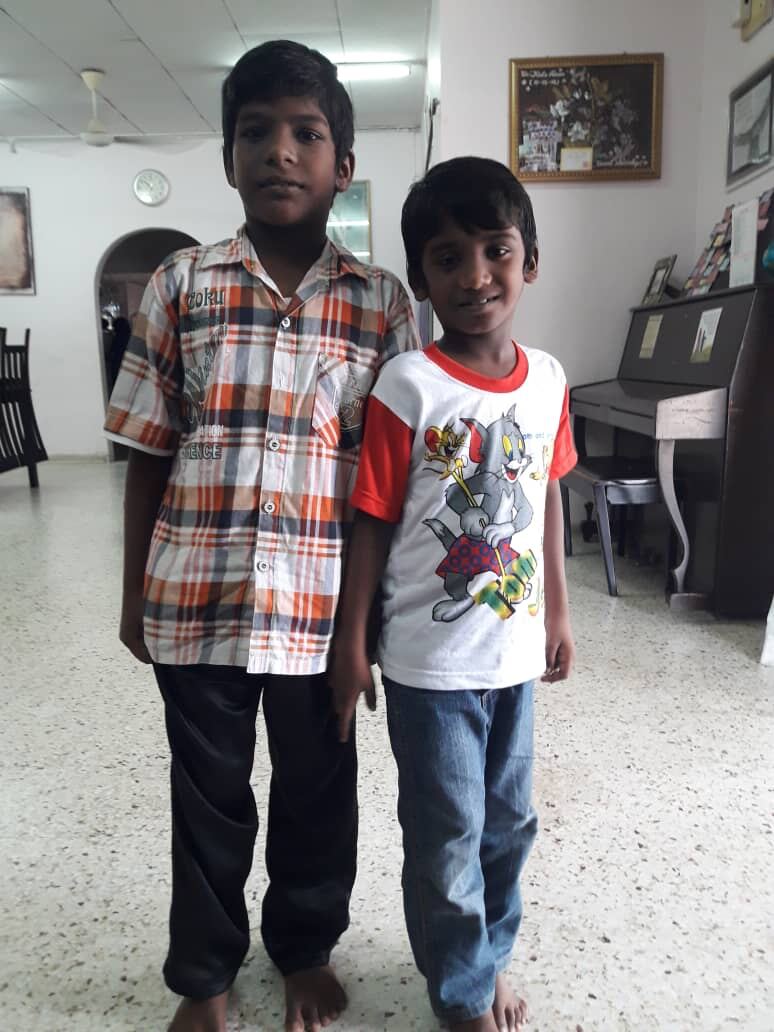 Two boys standing together indoors